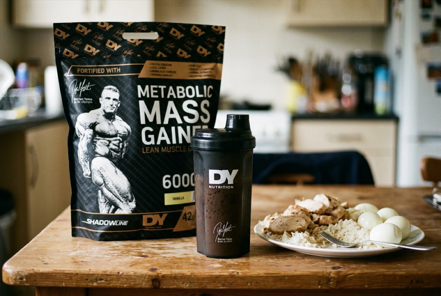 DY Metabolic Mass Gainer beside a shaker and a plate of chicken, rice and eggs